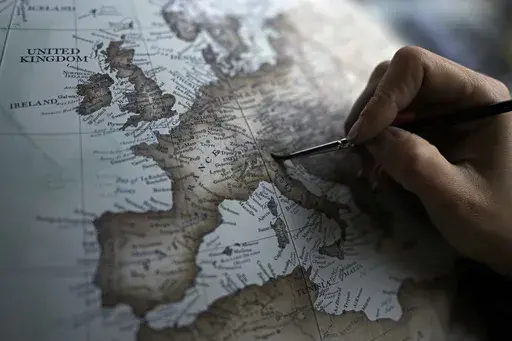 An artist paints a globe at a studio in London, Tuesday, Feb. 27, 2024. Globes in the age of Google Earth capture the imagination and serve as snapshots of how the owners see the world and their place in it. Peter Bellerby made his first globe for his father, after he could not find one accurate or attractive enough. In 2008, he founded Bellerby & Co. Globemakers in London. His team of dozens of artists and cartographers has made thousands of bespoke globes up to 50 inches in diameter. The most 