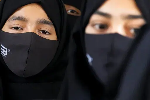 Indian Muslim students wearing hijabs and face masks gather to meet student activists in Kundapur in district Udupi, Karnataka state, India, Saturday, Feb. 26, 2022. An Indian court ruling upholding a ban on Muslim students wearing head coverings in schools has sparked criticism from constitutional scholars and rights advocates amid concerns of judicial overreach regarding religious freedoms. (AP Photo/Aijaz Rahi)