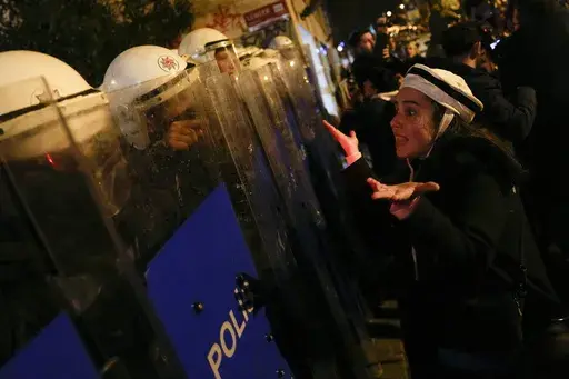 A protester argues with anti riot policemen at the end of the gathering to mark the International Women's Day in Istanbul, Turkey, Wednesday, March 8, 2023. Women in Turkey and their allies converged on a central Istanbul neighborhood to demonstrate for women's rights and protest the human-made toll of the deadly quake that hit Turkey a month ago. (AP Photo/Khalil Hamra)