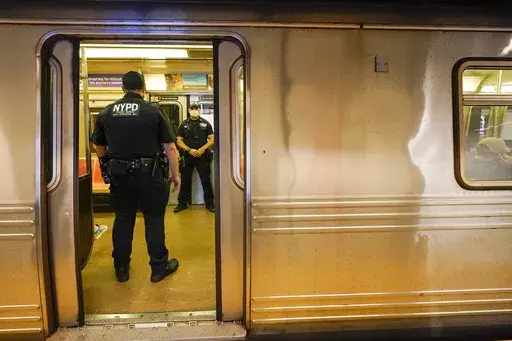 FILE- New York Police Officers with the Transit Bureau Anti Terrorism Unit board a train at the Canal St. Q station, Tuesday, May 24, 2022, in New York. False claims that New York City is experiencing a crime wave -- especially in Manhattan where Trump faces criminal charges - are spreading on social media following a congressional hearing on violence in the city on Monday, April 17, 2023. (AP Photo/Mary Altaffer, File)