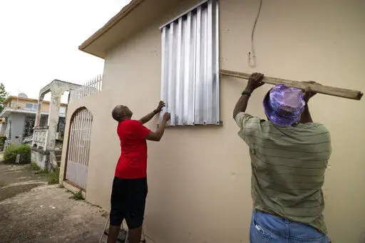 Residents prepare for the arrival of Tropical Storm Fiona, in Loiza, Puerto Rico, Saturday, Sept. 17, 2022. Fiona was expected to become a hurricane as it neared Puerto Rico on Saturday, threatening to dump up to 20 inches (51 centimeters) of rain as people braced for potential landslides, severe flooding and power outages. (AP Photo/Alejandro Granadillo)