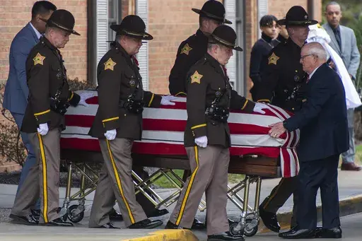 The casket of Vanderburgh County Sheriff's Deputy Asson Hacker is escorted to a hearse outside Boone Funeral Home in Evansville, Ind., on March 9, 2023. (MaCabe Brown/Evansville Courier & Press via AP)