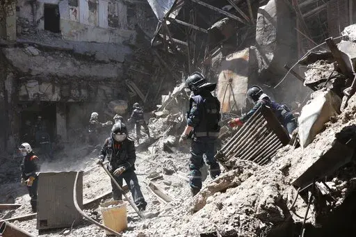 Donetsk People Republic Emergency Situations Ministry employees clear rubble at the side of the damaged Mariupol theater building during heavy fighting in Mariupol, in territory under the government of the Donetsk People's Republic, eastern Ukraine, Thursday, May 12, 2022. (AP Photo)
