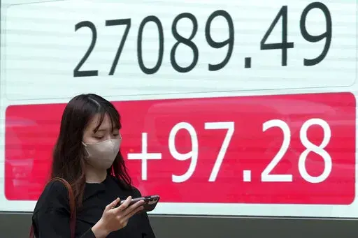A person walks in front of an electronic stock board showing Japan's Nikkei 225 index at a securities firm Wednesday, Oct. 5, 2022, in Tokyo. Hong Kong’s share benchmark soared more than 5% on Wednesday as Asian shares tracked gains on Wall Street. (AP Photo/Eugene Hoshiko)