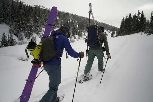 Michael Otenbaker and Joseph Burgoyne snowshoe into a backcountry ski area Wednesday, March 5, 2025, in Frisco, Colo. (AP Photo/Brittany Peterson)