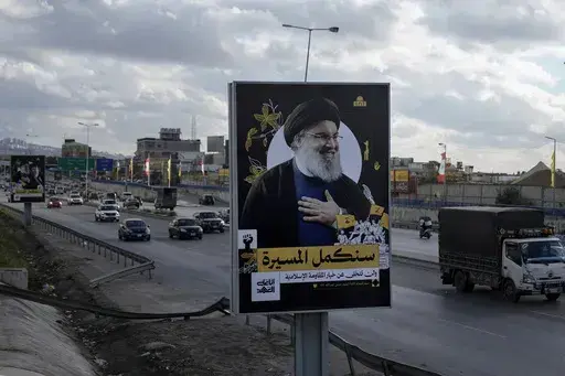 People drive past a billboard with a picture of the late Lebanon's Hezbollah leader Sayyed Hassan Nasrallah displayed on Beirut airport highway, Lebanon, Friday, Feb. 21, 2025. (AP Photo/Bilal Hussein)