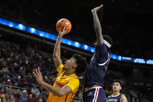 Iowa State guard Curtis Jones, left, is fouled by Jackson State guard Dorian McMillian, front right, while driving to the basket during the first half of an NCAA college basketball game Sunday, Dec. 8, 2024, in Ames, Iowa. (AP Photo/Charlie Neibergall)