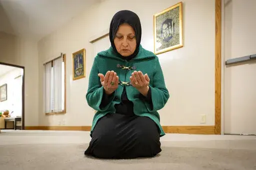 Bibi Bahrami prays at the Islamic Center of Muncie, Ind., on Friday, March 3, 2023, where she is one of the mosque's leaders. Bahrami is a subject of the documentary "Stranger at the Gate" that tells the story of the relationship she and others in their small Islamic community fostered with Richard McKinney, a former U.S. Marine who at one point had planned to bomb their community center. (AP Photo/Doug McSchooler)