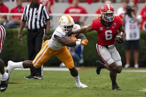 Georgia running back Kenny McIntosh, right, fends off Tennessee defensive lineman Byron Young during the first half of an NCAA college football game Saturday, Nov. 5, 2022 in Athens, Ga. (AP Photo/John Bazemore)