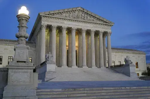 Light illuminates part of the Supreme Court building at dusk on Capitol Hill in Washington, Nov. 16, 2022. The court is set to hear arguments Wednesday in a case from North Carolina, where Republican efforts to draw congressional districts heavily in their favor were blocked by a Democratic majority on the state Supreme Court because the GOP map violated the state constitution. (AP Photo/Patrick Semansky, File)