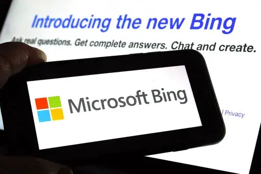 The Microsoft Bing logo and the website's page are shown in this photo taken in New York on Tuesday, Feb. 7, 2023. Microsoft is ready to take its new Bing chatbot mainstream — less than a week after making major fixes to stop the artificially intelligent search engine from going off the rails. The company said Wednesday, Feb. 22, it is bringing the new AI technology to its Bing smartphone app, as well as the app for its Edge internet browser. (AP Photo/Richard Drew)