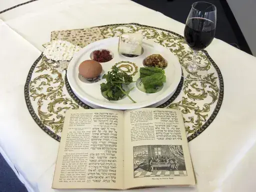 A 1936 Maxwell House Haggadah sits on a desk alongside a Seder plate on March 15, 2011, in New York. (AP Photo/Stace Maude, File)