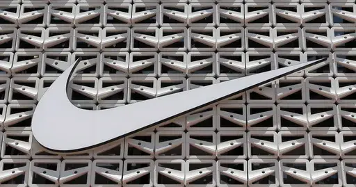 The Nike logo is shown on a store in Miami Beach, Fla. on Aug. 8, 2017. An agreement to weed out global tax havens and force multinational corporations, among them Apple and Nike, to pay a minimum tax has been weakened by loopholes and will raise only a fraction of the revenue that was envisioned, a tax watchdog backed by the European Union has warned. (AP Photo/Alan Diaz, File)