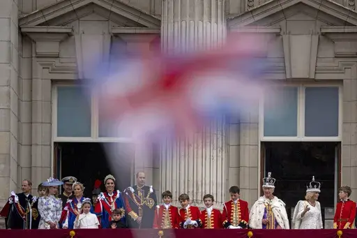 Britain's King Charles III and Queen Camilla wave to the crowds from the balcony of Buckingham Palace after the coronation ceremony in London, Saturday, May 6, 2023. King Charles III’s decision to be open about his cancer diagnosis has helped the new monarch connect with the people of Britain and strengthened the monarchy in the year since his dazzling coronation at Westminster Abbey. (AP Photo/ Andreea Alexandru, File)