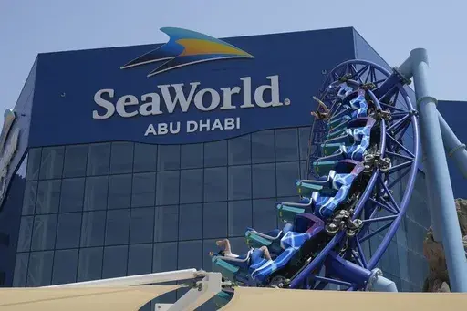 People enjoy riding on a roller coaster at the SeaWorld on Yas Island in Abu Dhabi, United Arab Emirates, on May 26, 2023. It’s the first venture outside the United States for the theme park chain, which had been mired in controversy in recent years over the treatment of captive killer whales. The $1.2 billion Abu Dhabi venture with state-owned developer Miral features the world's largest aquarium and cylindrical LED screen, as well as state-of-the-art facilities housing dolphins, seals, and o
