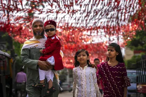 A Muslim family comes to offer Eid al-Fitr prayers in Gauhati, India, Tuesday, May 3, 2022. Eid al-Fitr marks the end of the fasting month of Ramadan. (AP Photo/Anupam Nath)