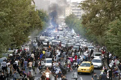 In this photo taken by an individual not employed by the Associated Press and obtained by the AP outside Iran, protesters chant slogans during a protest over the death of a woman who was detained by the morality police, in downtown Tehran, Iran, Sept. 21, 2022. (AP Photo, File)