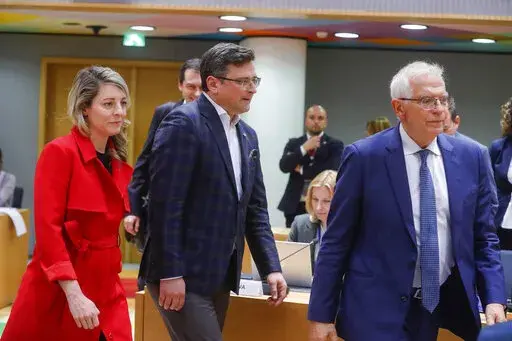 Ukraine's foreign minister Dmytro Kuleba, center, Canada's foreign minister Melanie Joly, left, and European Union foreign policy chief Josep Borrell arrive at a meeting of EU foreign ministers at the European Council building in Brussels, Monday, May 16, 2022. European Union foreign ministers on Monday will discuss current affairs and have an exchange of views on the Russian aggression against Ukraine and the Global Gateway. (Stephanie Lecocq/Pool Photo via AP)