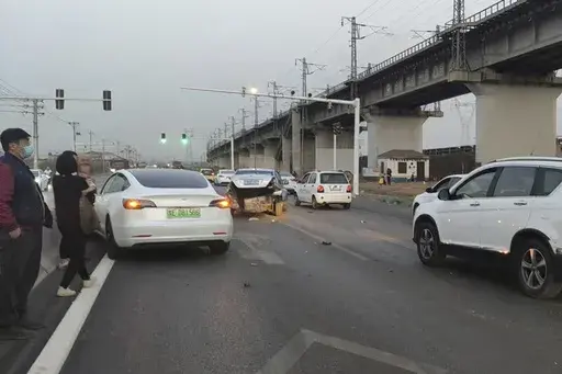 This photo provided by Zhang Yazhou shows her damaged Tesla Model 3, left, which her father was driving when it hit two other cars before crashing to a halt against a concrete barrier in Anyang, a city in central China’s Henan province, on Feb. 21, 2021. Zhang was in the passenger seat. Her mother and her one-year-old niece were at the back. (Zhang Yazhou via AP)
