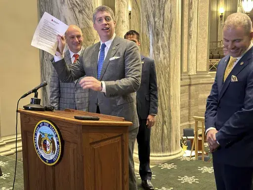 Missouri state Sen. Bill Eigel, a Republican member of the state Freedom Caucus, waives a paper containing criticisms of the Freedom Caucus that had been prepared by Republican Senate leaders for a press conference on Thursday, Jan. 25, 2024, at the state Capitol in Jefferson City, Mo. Republican leaders had left the paper on a lectern which the Freedom Caucus then used for its own press conference. (AP Photo/David A. Lieb)