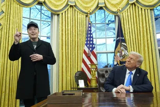 President Donald Trump listens as Elon Musk speaks in the Oval Office at the White House, Feb. 11, 2025, in Washington. (AP Photo/Alex Brandon, File)