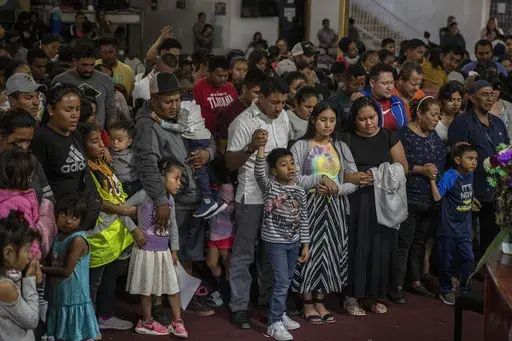 Mexican migrants, many from Michoacan state, attend a religious service at the "Embajadores de Jesus" Christian migrant shelter in Tijuana, Mexico, Tuesday, Sept. 26, 2023. While many places in Mexico provide shelter for migrants from other countries, some shelters in Tijuana have seen an influx of Mexicans fleeing violence, extortion and threats by organized crime. (AP Photo/Karen Castaneda)