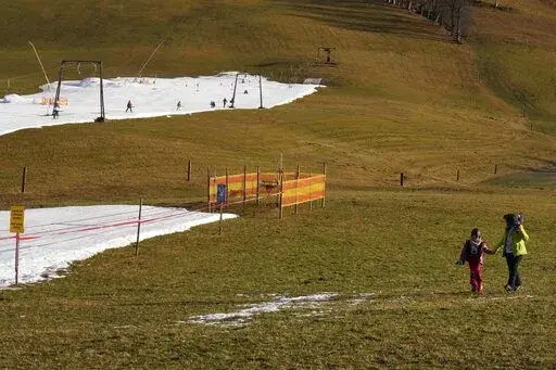 People walk across a slope in Filzmoos, Austria, on Jan. 6, 2023. Europe has dodged an energy apocalypse this winter, economists and officials say, thanks to unusually warm weather and efforts to find other sources of natural gas after Russia cut off most of its supply to the continent. (AP Photo/Matthias Schrader, File)
