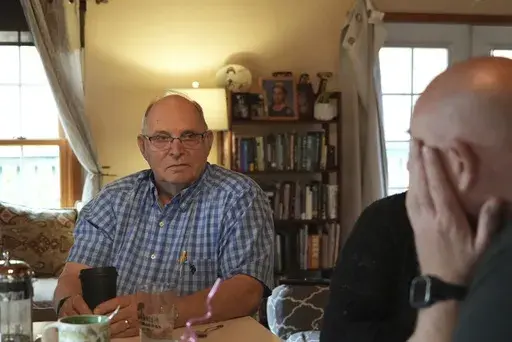 Doug Whitney, left, looks at his son, Brian, in Manson, Wash., on Nov. 5, 2022. Doug inherited the same gene mutation that gave Alzheimer's disease to his mother, brother and generations of other relatives by the unusually young age of 50. Doug is a healthy 73, his mind still sharp. Somehow, he escaped his genetic fate. Brian, who also inherited the devastating family gene, has reached the fateful age of 50 without symptoms but knows that’s no guarantee. (AP Photo/Shelby Lum)