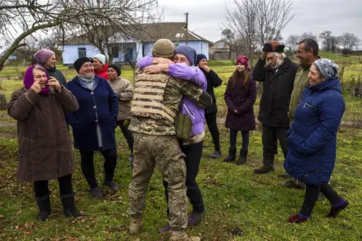 In the village of Vavylove, a Ukrainian serviceman embraces his mother for the first time since Russian troops withdraw from the Kherson region, southern Ukraine, Sunday, Nov. 13, 2022. Families were torn apart when Russia invaded in February, as some fled and others hunkered down. Now many are seeing one another for the first time in months, after Moscow's latest retreat amid a Ukrainian counteroffensive that has retaken a pocket of territory wedged between the regional capitals of Kherson and 