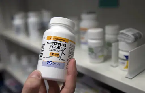 A pharmacist holds a bottle of the antibiotic doxycycline hyclate in Sacramento, Calif., July 8, 2016. On Tuesday, April 11, 2023, the Centers for Disease Control and Prevention released data about some of the most common infectious diseases in the U.S. The numbers show how chlamydia, gonorrhea and syphilis infections have been accelerating across the country. Meanwhile, the CDC is considering recommending the antibiotic doxycycline to be used after sex to prevent those infections. (AP Photo/Ric