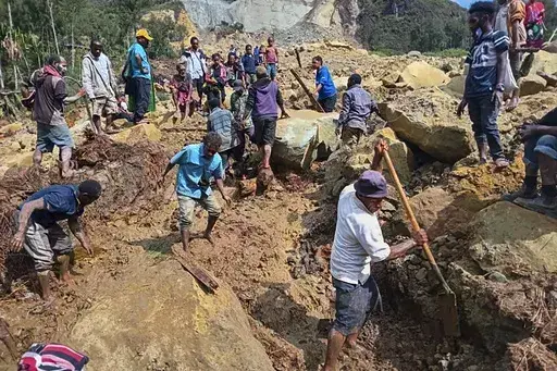 CORRECTS TO YAMBALI FOR LOCATION, NOT POGERA - Villagers search through a landslide in Yambali, in the Highlands of Papua New Guinea, Sunday, May 26, 2024. The International Organization for Migration feared Sunday the death toll from a massive landslide is much worse than what authorities initially estimated. (Mohamud Omer/International Organization for Migration via AP)