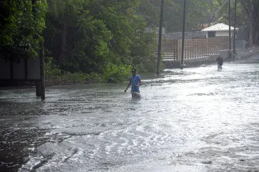 A man walks through a flooded road in the coast of the Indian Ocean Island of Mauritius Monday Feb. 20, 2023. Forecasts say Tropical Cyclone Freddy is increasing in intensity and is expected to pass north of the Indian Ocean island nation of Mauritius and make landfall in central Madagascar Tuesday evening.It's feared that up to 2.2 million people, mostly in Madagascar, will be impacted by storm surges and flooding, according to the Global Disaster Alert and Coordination System.(AP Photo/L'expre