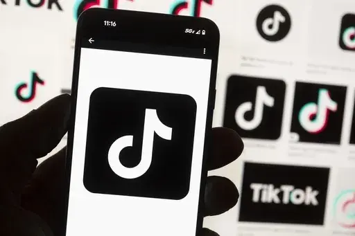 The TikTok logo is seen on a mobile phone in front of a computer screen which displays the TikTok home screen, Oct. 14, 2022, in Boston. (AP Photo/Michael Dwyer, File)
