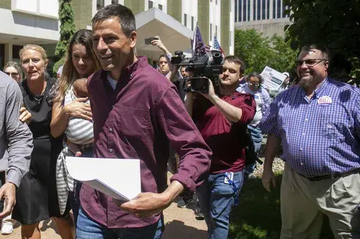 Michigan gubernatorial candidate Ryan Kelly leaves the U.S. District Court in Grand Rapids, Mich., with his family and supporters on June 9, 2022. The former Republican candidate for Michigan governor pleaded guilty on July 27, 2023, to a misdemeanor charge for his participation in the U.S. Capitol riot on Jan. 6, 2021. (Daniel Shular/The Grand Rapids Press via AP)