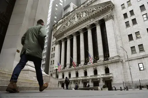 FILE — People pass the front of the New York Stock Exchange, March 22, 2023. The average Wall Street bonus fell slightly last year to $176,500 as firms took a “more cautious approach” to compensation, New York state’s comptroller reported Tuesday, March 19, 2024. (AP Photo/Peter Morgan, File)