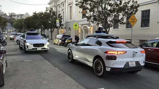 Two Waymo driverless taxis stop and face each other on a street in San Francisco before driving past each other, on Feb. 15, 2023. Cruise, a subsidiary of General Motors, and Waymo, a spinoff from Google, both are on the verge of operating 24-hour services that would transport passengers throughout one of the most densely populated U.S. cities in vehicles that will have no one sitting in the driver’s seat. (AP Photo/Terry Chea)