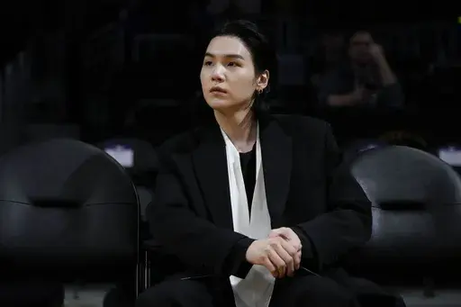 BTS member Suga attends an NBA basketball game between the Los Angeles Lakers and the Dallas Mavericks on Jan. 12, 2023, in Los Angeles. Suga has become the third member of BTS to begin South Korea’s compulsory military service. BTS' label, Big Hit Music, said in a statement on Monday, Aug. 7, 2023, that Suga "has initiated the military enlistment process by applying for the termination of his enlistment postponement.” (AP Photo/Jae C. Hong, File)