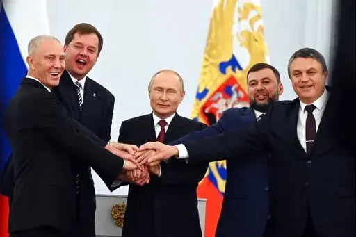 From left, Moscow-appointed head of Kherson Region Vladimir Saldo, Moscow-appointed head of Zaporizhzhia region Yevgeny Balitsky, Russian President Vladimir Putin, center, Denis Pushilin, leader of self-proclaimed of the Donetsk People's Republic and Leonid Pasechnik, leader of self-proclaimed Luhansk People's Republic pose for a photo during a ceremony to sign the treaties for four regions of Ukraine to join Russia, at the Kremlin in Moscow, on Sept. 30, 2022. (Grigory Sysoyev, Sputnik, Kremlin