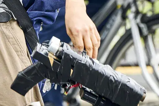 Suspect Tetsuya Yamagami holds a weapon, as he is detained near the site of gunshots in Nara, western Japan, Friday, July 8, 2022. The shooting of former Japanese Prime Minister Shinzo Abe sent shudders through low-crime, orderly Japan: A high-profile politician gets killed by a man emerging from a crowd, wielding a handmade firearm so roughly made it’s wrapped up in tape. (Nara Shimbun/Kyodo News via AP)