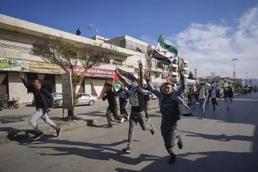 Syrians celebrate the fall of Bashar Assad's government in the town of Bar Elias, Lebanon, near the border with Syria, Sunday, Dec. 8, 2024. (AP Photo/Hassan Ammar, File)