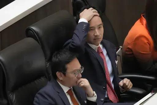 Pita Limjaroenrat, right, the leader of Move Forward Party and top winner in the May's general election, reacts during vote counting at the Parliament in Bangkok, Thailand, Thursday, July 13, 2023. Pita, whose Move Forward Party ran first in Thailand's May 14 general election, was nominated to be prime minister at a joint session of Parliament's Upper and Lower House on Thursday, but failed to attain the majority vote needed to win the job, necessitating a new round of voting expected next week.
