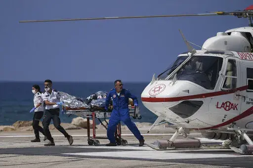Israeli medics rush an injured man for treatment at the Rambam Hospital in the northern Israeli city of Haifa, following a shooting attack in the West Bank at the Jordan Valley, Sunday, Sept. 4, 2022. The Israeli military said that Palestinian gunmen opened fire on a bus in the occupied West Bank, wounding six soldiers, one of them seriously, and a civilian. (AP Photo/Ariel Schalit)