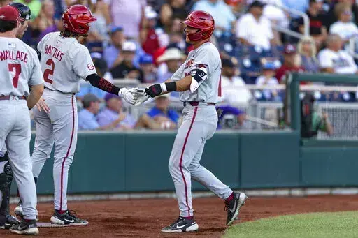 Arkansas' Chris Lanzilli (18) gets five from Jalen Battles (2) after his home run in the second inning against Mississippi during an NCAA College World Series baseball game Wednesday, June 22, 2022, in Omaha, Neb. (AP Photo/John Peterson)