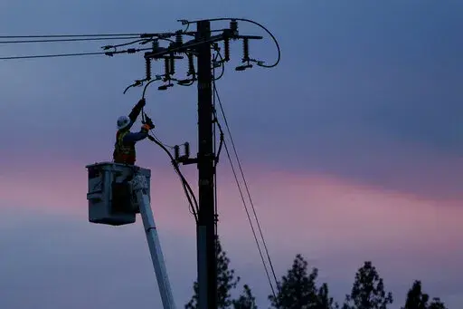 In this Nov. 26, 2018, file photo, a Pacific Gas & Electric lineman works to repair a power line in fire-ravaged Paradise, Calif. Emergencies such as power outages or severe weather can happen at any time and can be costly. Unplanned hotel stays, lost documents and damaged property are just a few of the expensive outcomes. (AP Photo/Rich Pedroncelli, File)