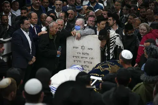 Mourners attend the funeral of Israeli couple Eli Mizrahi and his wife, Natalie, victims of a shooting attack Friday in east Jerusalem, at the cemetery in Beit Shemesh, Israel, early Sunday, Jan. 29, 2023. On Friday a Palestinian gunman opened fire outside an east Jerusalem synagogue, killing the couple and another five people, including a 70-year-old woman, and wounding three others before he was shot and killed by police, officials say. It was the deadliest attack on Israelis since 2008 and ra