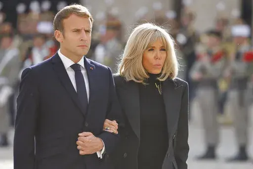 FILE. French President Emmanuel Macron and his wife Brigitte Macron attend a national memorial ceremony for Hubert Germain at the Hotel des Invalides, Friday Oct.15, 2021 in Paris. A group of "atypical journalists," on the autism spectrum, got France's 45-year-old president to talk about himself with unusual and illuminating candour in a televised interview this weekend. (Ludovic Marin, Pool Photo via AP)