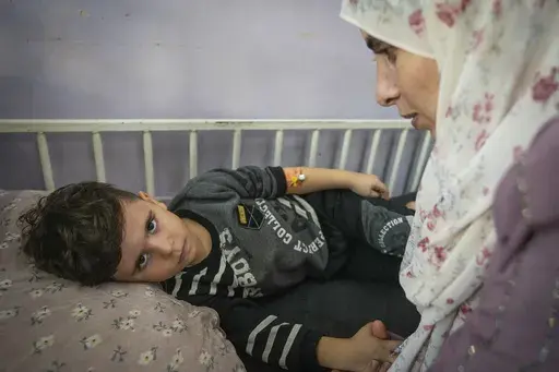 Nima al-Askari, right, cares for her 4-year-old son, Qusay al-Askari, in Deir al-Ballah, Gaza Strip, on Nov. 16, 2024. Nima al-Askari said she was told by doctors that her son could become paralyzed if he doesn't get surgery in the next two or three months for a heart defect that constricts his aorta. (AP Photo/Abdel Kareem Hana)