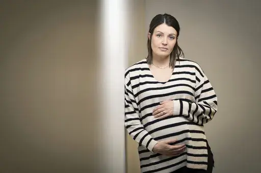 Jillaine St.Michel stands for a portrait in Boise, Idaho on Saturday, Dec. 2, 2023. A year earlier, she learned that her previous 20-week fetus had multiple genetic and developmental problems and probably wouldn’t survive. She lives in Idaho, which has a ban on abortions, so St.Michel and her husband called about 15 out-of-state clinics, finally getting on a three-week waiting list in Denver and a two-week waiting list in Seattle. Pregnant again, she is due to give birth to a boy in January. (