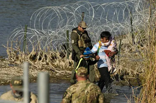 Migrants are taken into custody by officials at the Texas-Mexico border, Jan. 3, 2024, in Eagle Pass, Texas. The Supreme Court on Tuesday, March 12, 2024 extended a stay on a new Texas law that would empower police to arrest migrants suspected of illegally crossing the U.S.-Mexico border. The order puts the law on hold until at least Monday while the high court considers a challenge by the Justice Department, which has called the law an unconstitutional overreach. (AP Photo/Eric Gay, file)