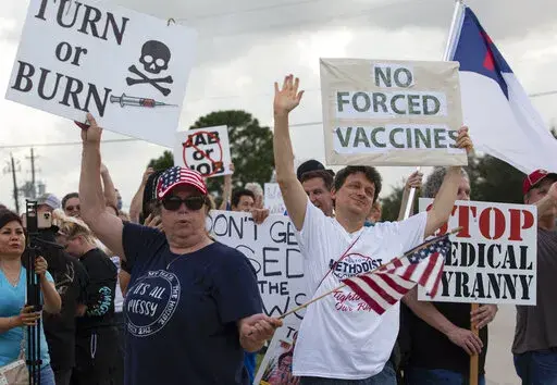 In this June 7, 2021, photo, demonstrators at Houston Methodist Baytown Hospital in Baytown, Texas, wave at cars that honk at them to support their protest against a policy that says hospital employees must get vaccinated against COVID-19 or lose their jobs. Religious exemptions are increasingly becoming a workaround for hospital and nursing home staff who want to keep their jobs in the face of federal COVID-19 vaccine mandates that are going into effect nationwide this week. (Yi-Chin Lee/Housto
